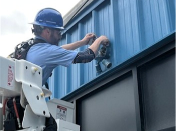 Picture shows a Public Works employee performing building maintenance at the Public Works facility.
